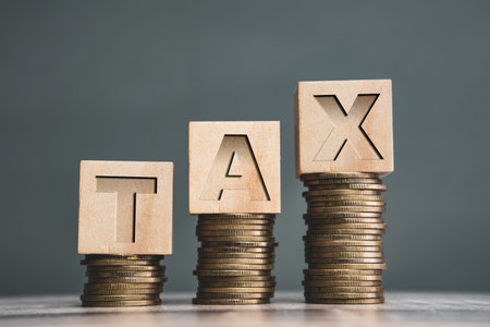 Tax Concept with wooden block on stacked coins.Income tax return.