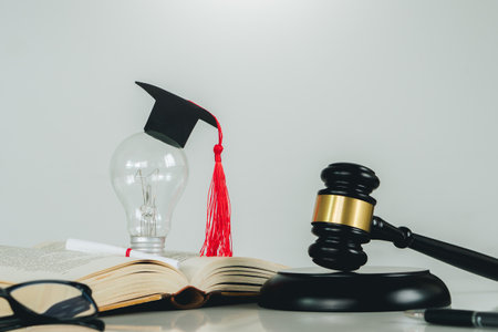 Education law concept.Scales of justice,law books,Graduation cap,light blub and book with white background.Justice legal and jurisprudence concept.の写真素材