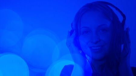 Attractive young woman with headphones music backgroundの写真素材