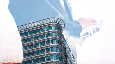 London office building double exposure with businessman using tabletの写真素材