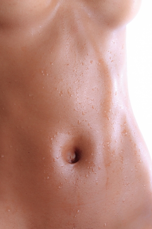 Wet abdomen of a black nude young womanの写真素材
