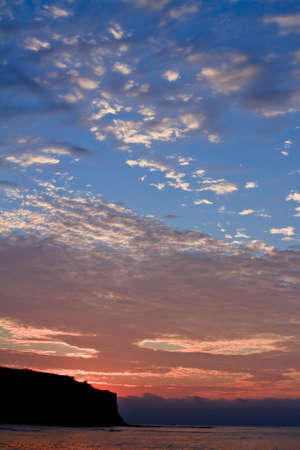 sunset at coast of the sea with two colored skyの写真素材