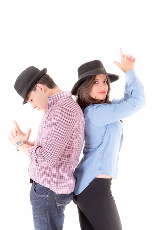 Couple back to back with hats and hands gesturing gunsの写真素材