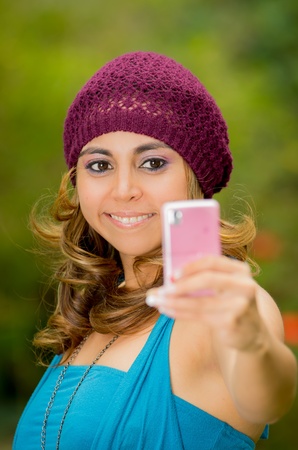 Pretty woman taking pictures from her cell phoneの写真素材