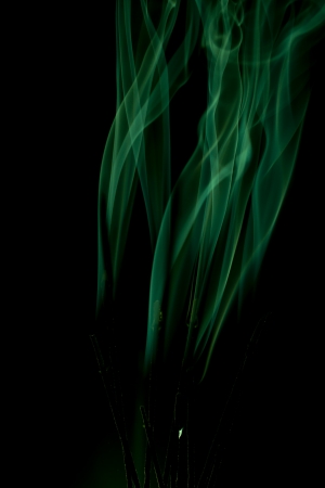 Green smoke rises up on a black background の写真素材