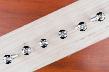 screws screwed in wood plateの写真素材