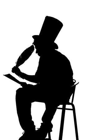 silhouette man sitting on a stool while writingの写真素材