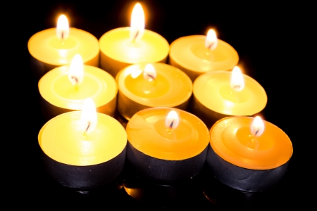 Group of burning candles on  black background の写真素材