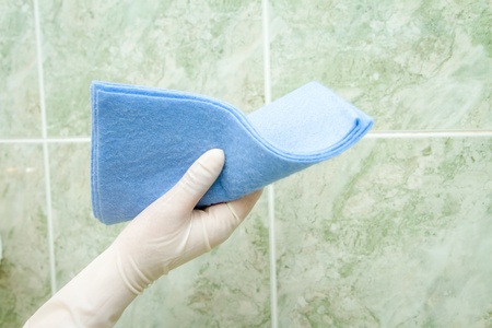 female hand cleaning kitchen tiles with spongeの写真素材