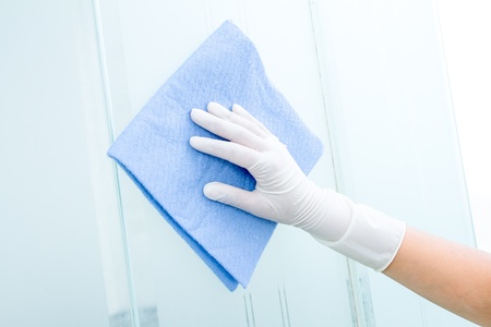 Hand and glove  with blue sponge cleaning glassの写真素材