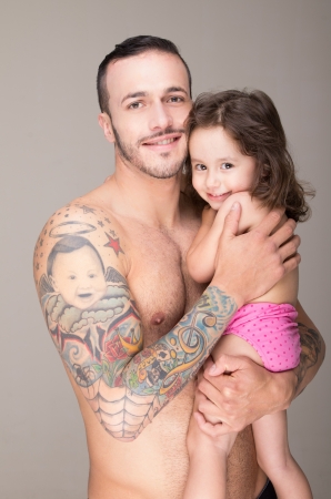 Baby on hands at the man with a tattooの写真素材
