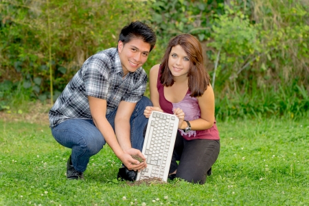 couple plant a keyboard into the groundの写真素材