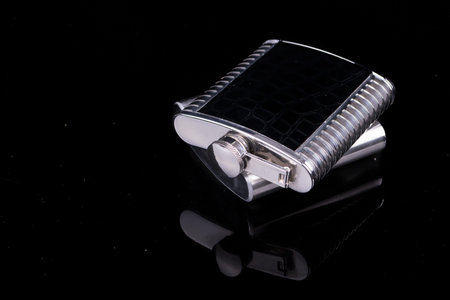 Hip flask on black background 