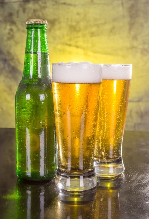 Glasses of beer with green bottleの写真素材
