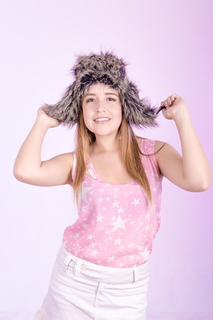 Hapy girl in fur cap and pink backgroundの写真素材