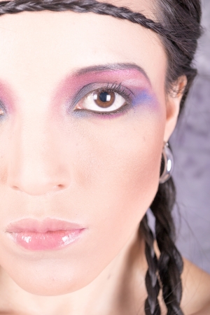 Hippie girl with purple makeup and breaded hair on foreheadの写真素材