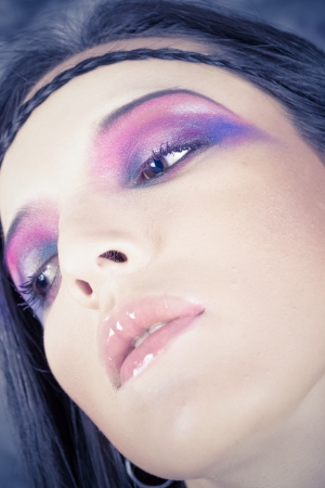 Hippie girl with purple makeup and breaded hair on foreheadの写真素材