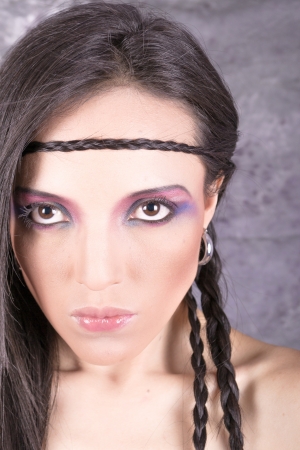 Hippie girl with purple makeup and breaded hair on foreheadの写真素材