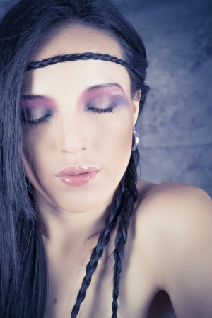 Hippie girl with purple makeup and breaded hair on foreheadの写真素材