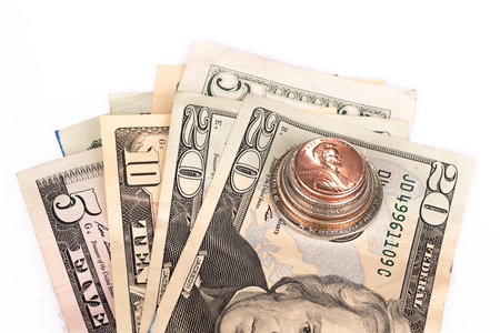 Several stacks of American coins with some dollar bills.
