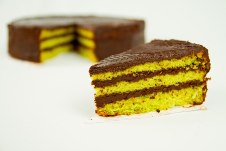 slice of rich moist chocolate cake isolated on whiteの写真素材