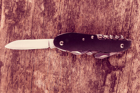 black swiss army knife on wood color tonedの写真素材