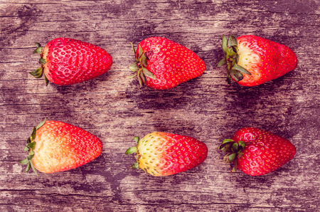 strawberries lying on a plate of woodの写真素材
