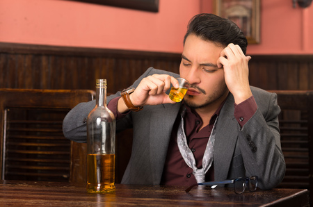 latin american man in suit drinking alcohol shot の写真素材