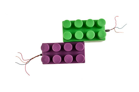green and purple building blocks connected to open wires isolated on white