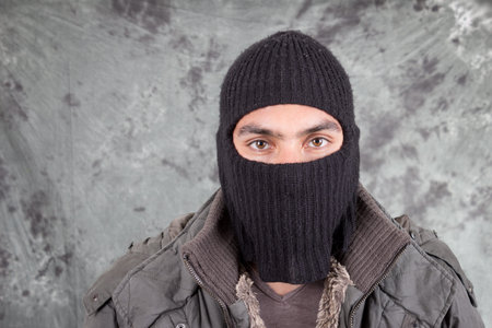 portrait of unrecognizable man wearing black hoodie over grey blackground