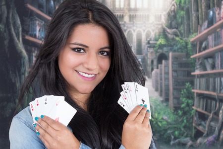 Beautiful young girl holding aces from deck of cards with both handsの写真素材