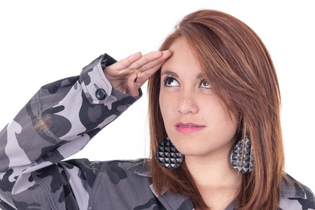 Pretty young girl in military uniform saluting closeup isolated on whiteの写真素材
