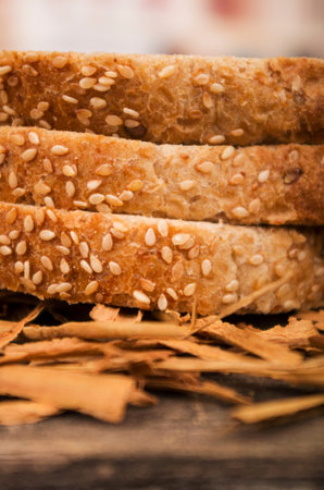 closeup slices of whole bread with sesame seeds on wooden table