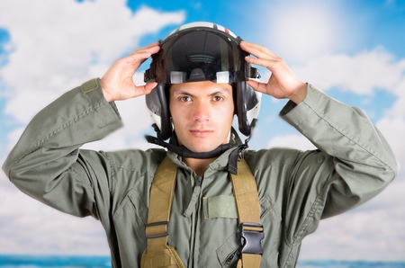 closeup portrait of young pilot holding helmet with a sky backgroundの写真素材