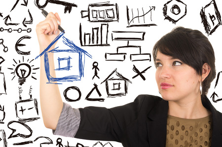 young beautiful woman drawing a house with marker concept of home family investment insurance isolated on whiteの写真素材