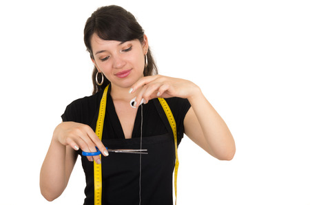 portrait young woman tailor designer seamstress cutting thread with scissors isolated on whiteの写真素材