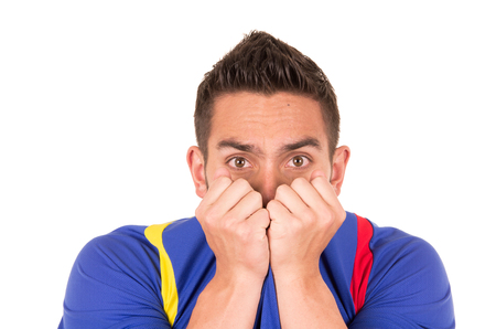 nervous soccer fan wearing blue tshirt watching game isolated on whiteの写真素材