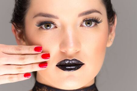 young gothic beautiful woman with black makeup and red nailsの写真素材