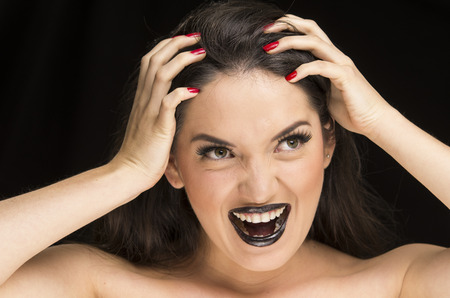 young gothic desperate woman with black makeup and red nailsの写真素材