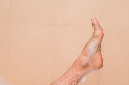 closeup of woman's foot covered with foam bubble bathの写真素材