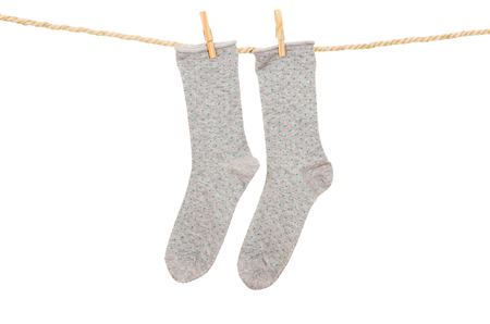 socks hanging on a rope clothesline isolated on whiteの写真素材