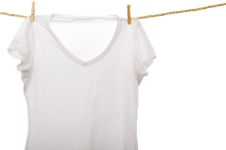 white tshirt hanging on a rope clothesline isolated on whiteの写真素材
