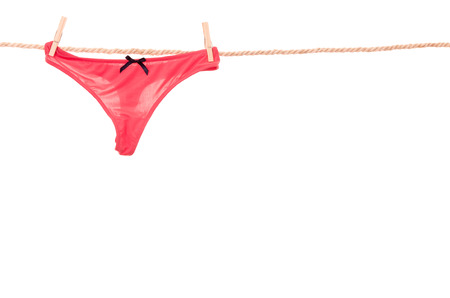 red panties hanging on a rope clothesline isolated on whiteの写真素材