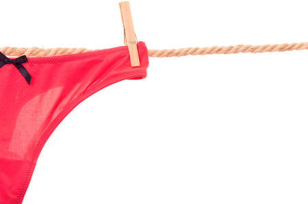 red panties hanging on a rope clothesline isolated on whiteの写真素材