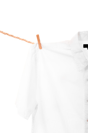 white shirt hanging on a rope clothesline isolated on whiteの写真素材