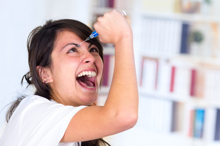 young crazy woman injecting herself with a syringeの写真素材