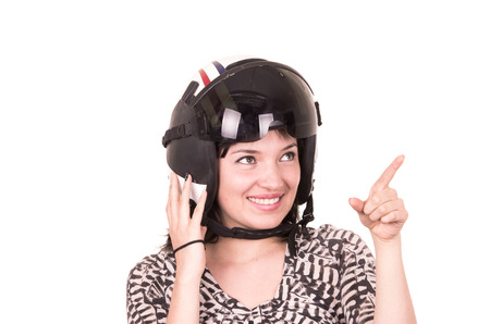 beautiful fun happy young girl wearing a helmet pointing up isolated on whiteの写真素材