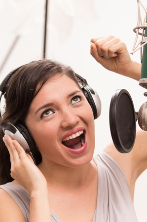 beautiful young brunette girl singing in music studioの写真素材