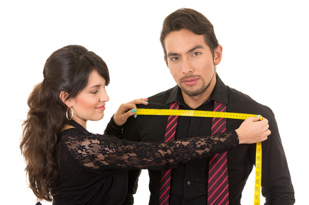 young beautiful woman tailor designer taking measures of male clients chest isolated on whiteの写真素材