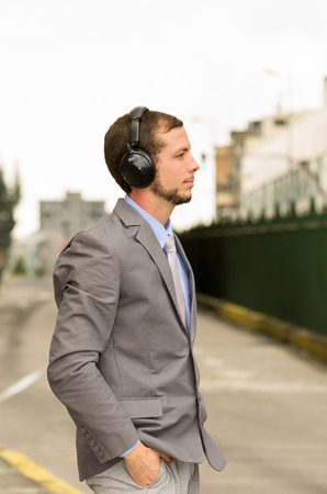 young stylish handsome man wearing headphones in the city outdoorsの写真素材